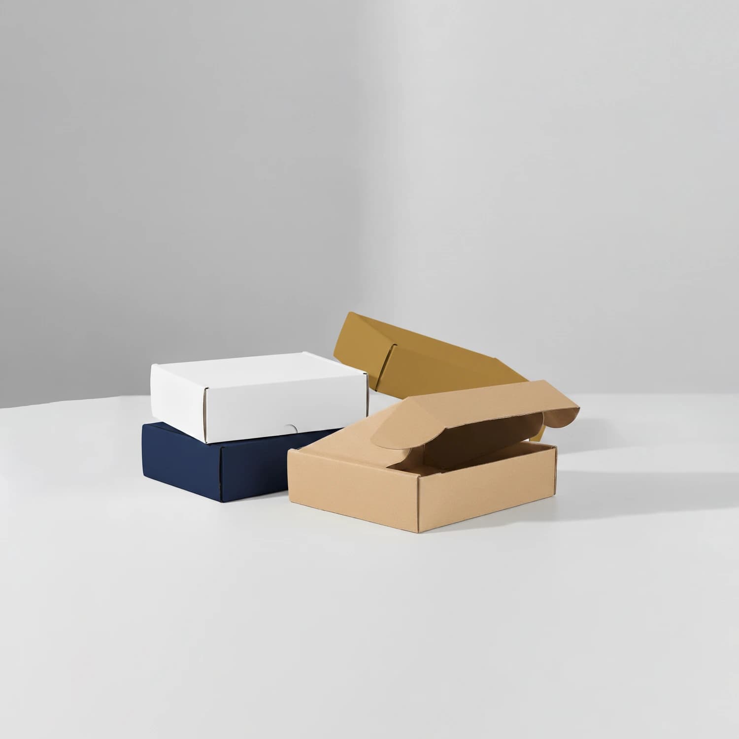 Assorted mailer boxes in kraft, white, navy, and mustard, with open and closed lids
