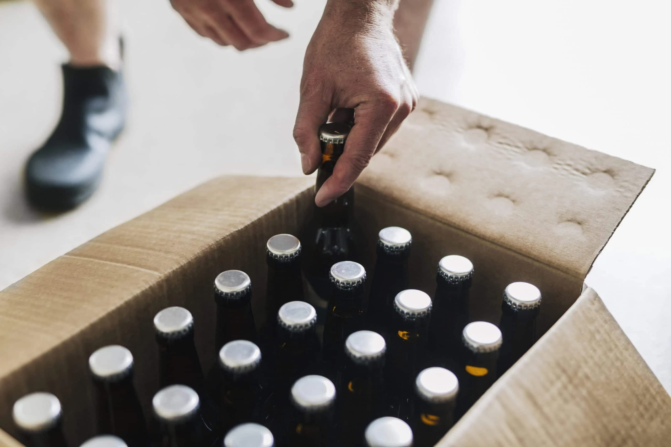 /beer-packaging/brewery-worker-putting-beer-bottles-into-cardboard.webp
