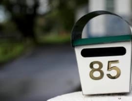 Staff measuring a custom mailer box to minimise postage costs